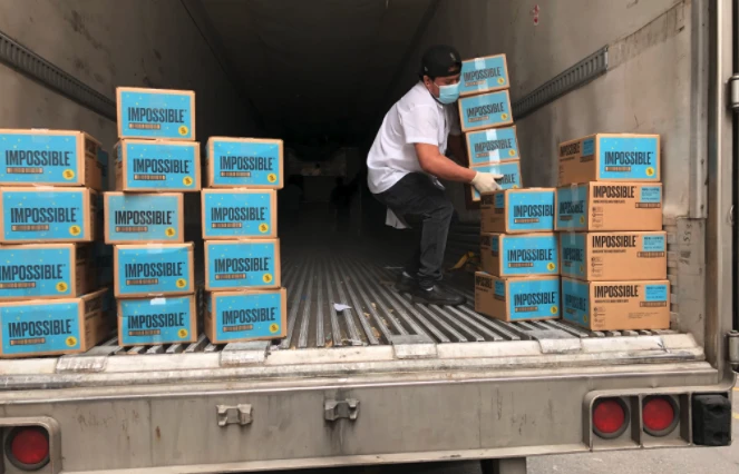 Man loading boxed of Impossible Food and Impossible Burger from truck Plant Based Meat Alternatives