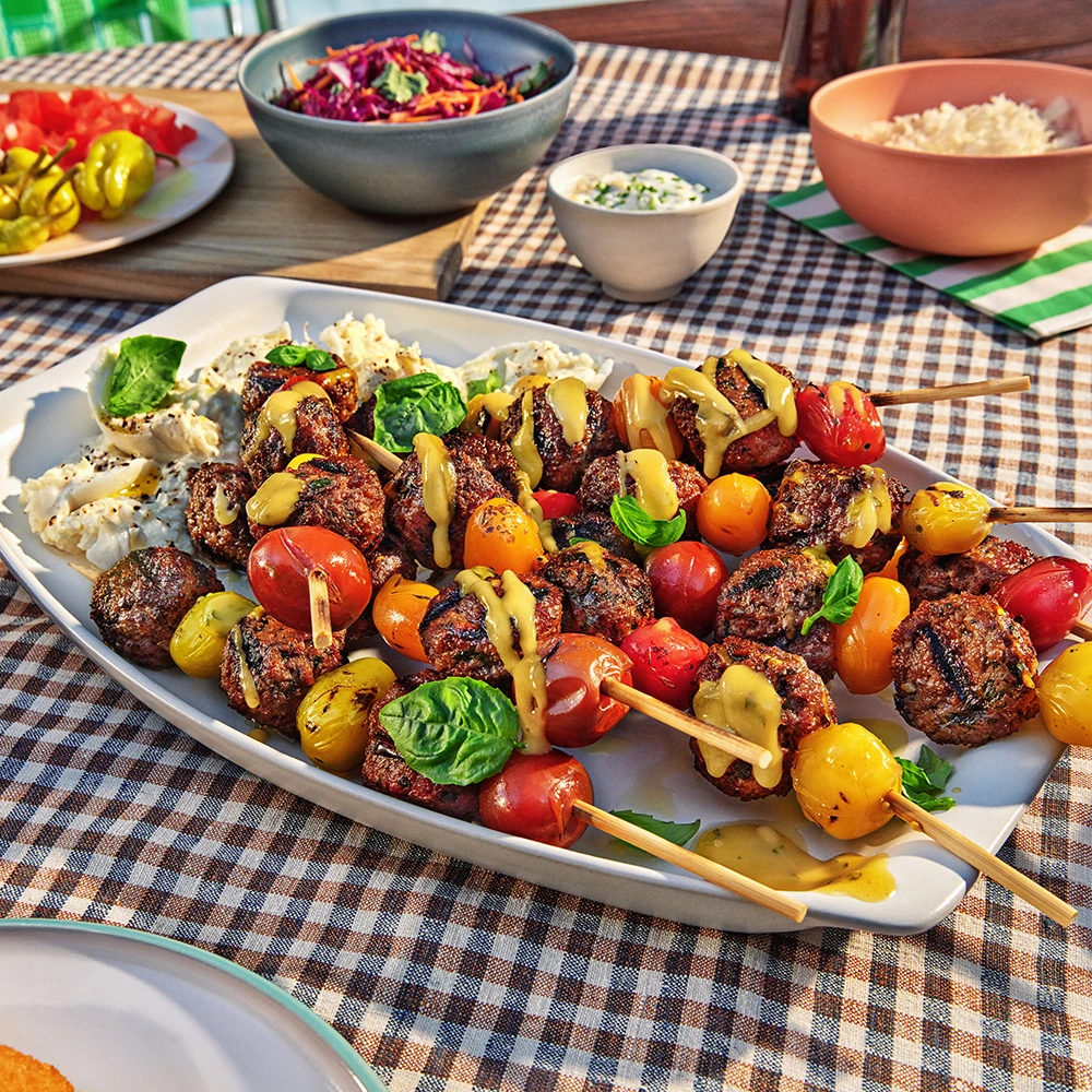 A platter of Impossible Beef Caprese Skewers drizzled with lemon basil vinaigrette with fresh burrata cheese. 