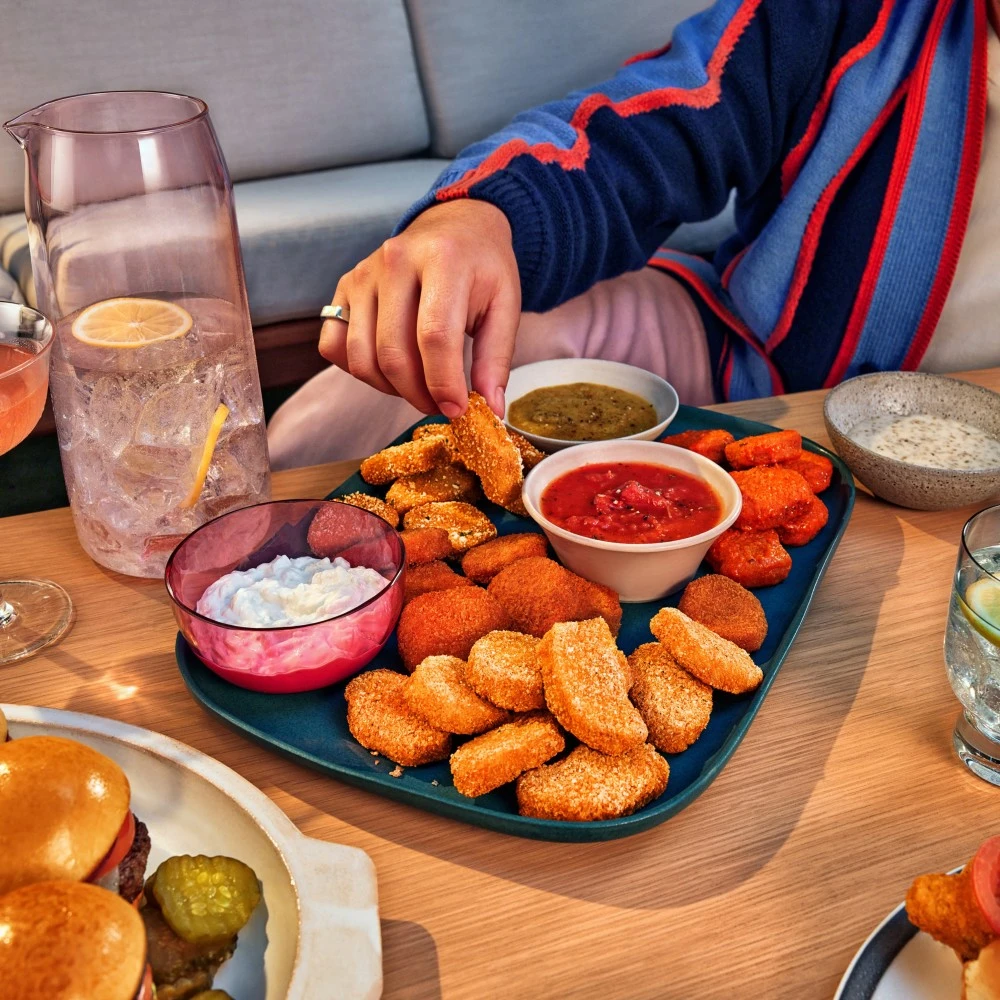 Four different types of Impossible Chicken Nugget Boneless Wings with four different types of dipping sauces, on a large platter, ready to be enjoyed. 