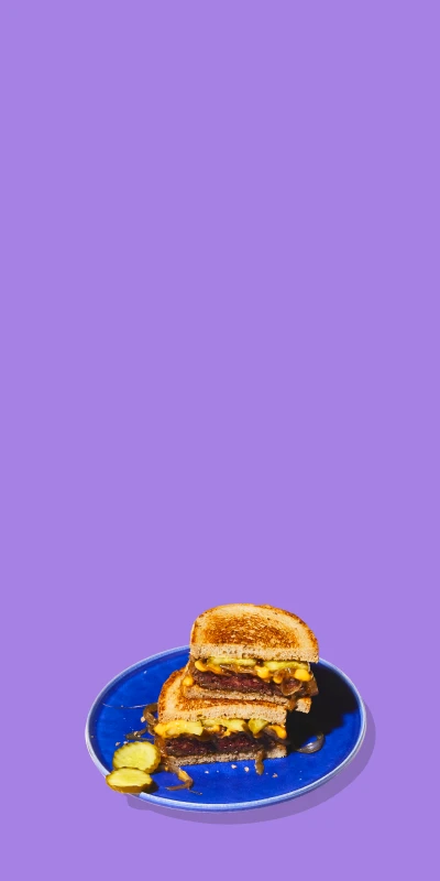 Impossible Burger Patty Melts on plates on purple background