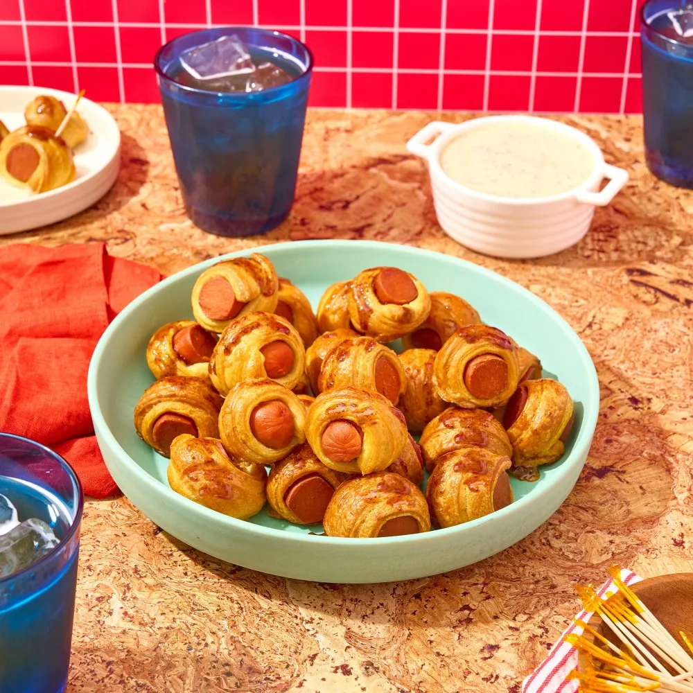 A large bowl of pigs in a blanket made with Impossible Beef Hot Dogs made from plants, ready to be dunked in a whole grain honey mustard dipping sauce. 