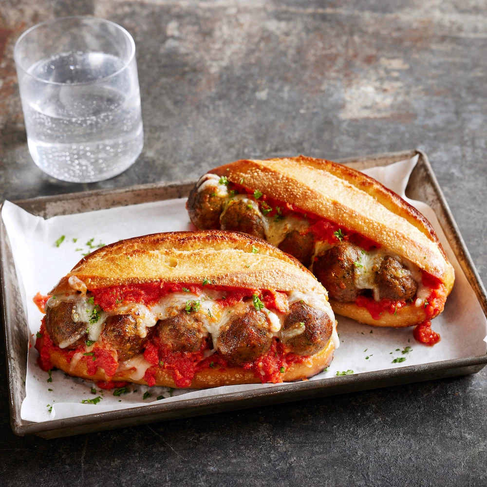 Impossible™ Meatball Sub sandwich made with Impossible Meatballs Made From Plants in a rich marinara sauce with melted cheese and herbs, tucked into a toasted hoagie roll.