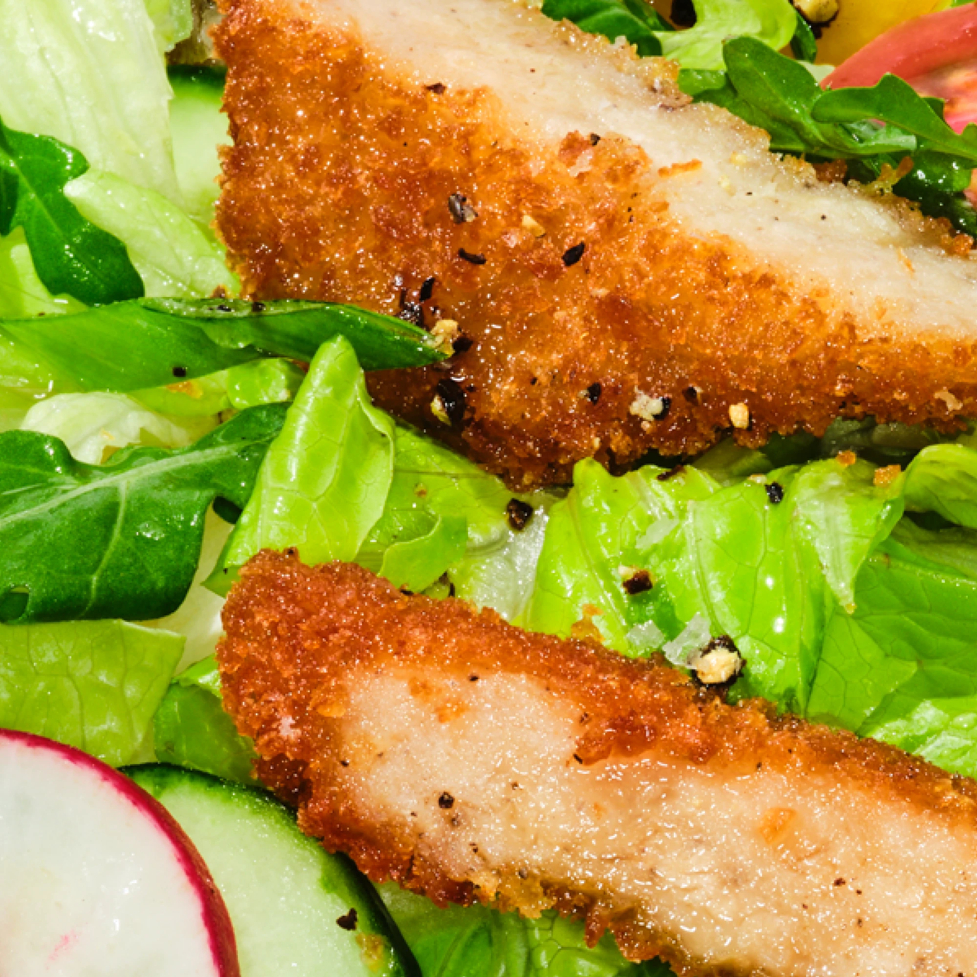 zoomed in shot of impossible chicken tenders cut up in a salad