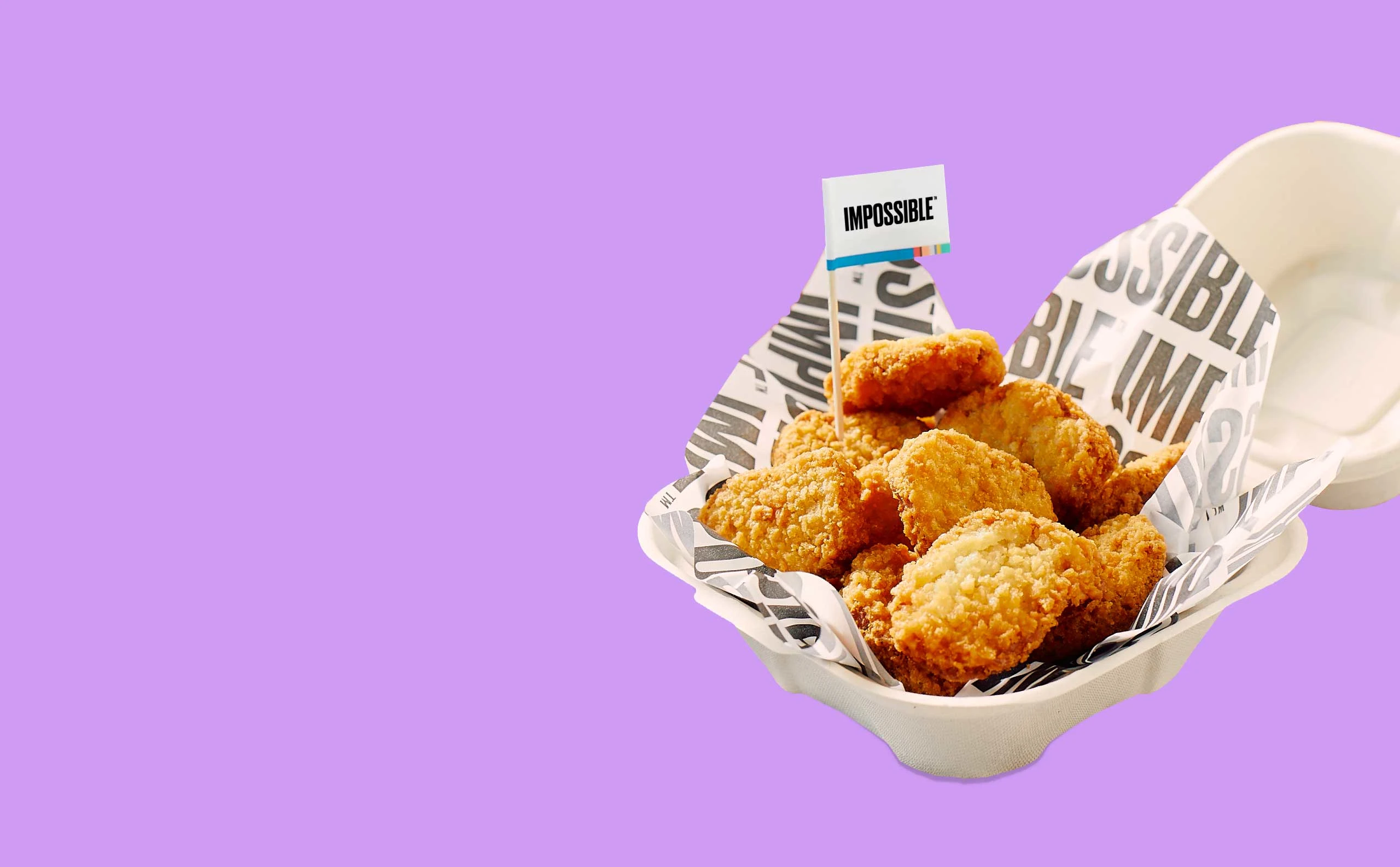Impossible Chicken Nuggets with an Impossible toothpick flag in a takeout container on a purple background