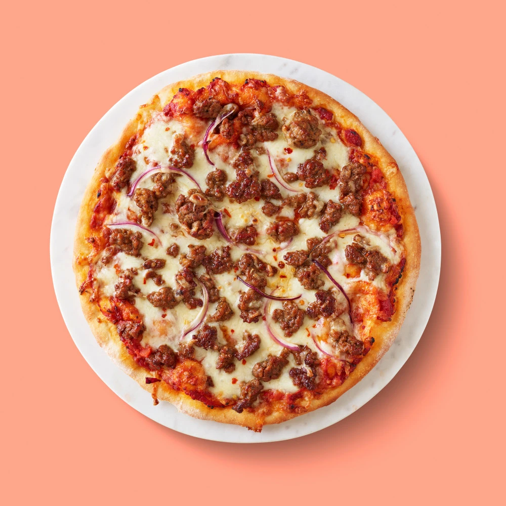 Impossible™ Spicy Sausage & Red Onion Pizza slices made with Impossible™ Spicy Sausage Made From Plants