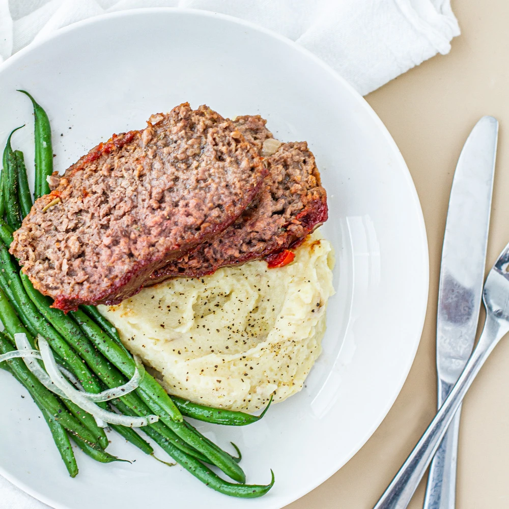 BBQ Impossible Burger with mashed potatoes and green beans on white plate