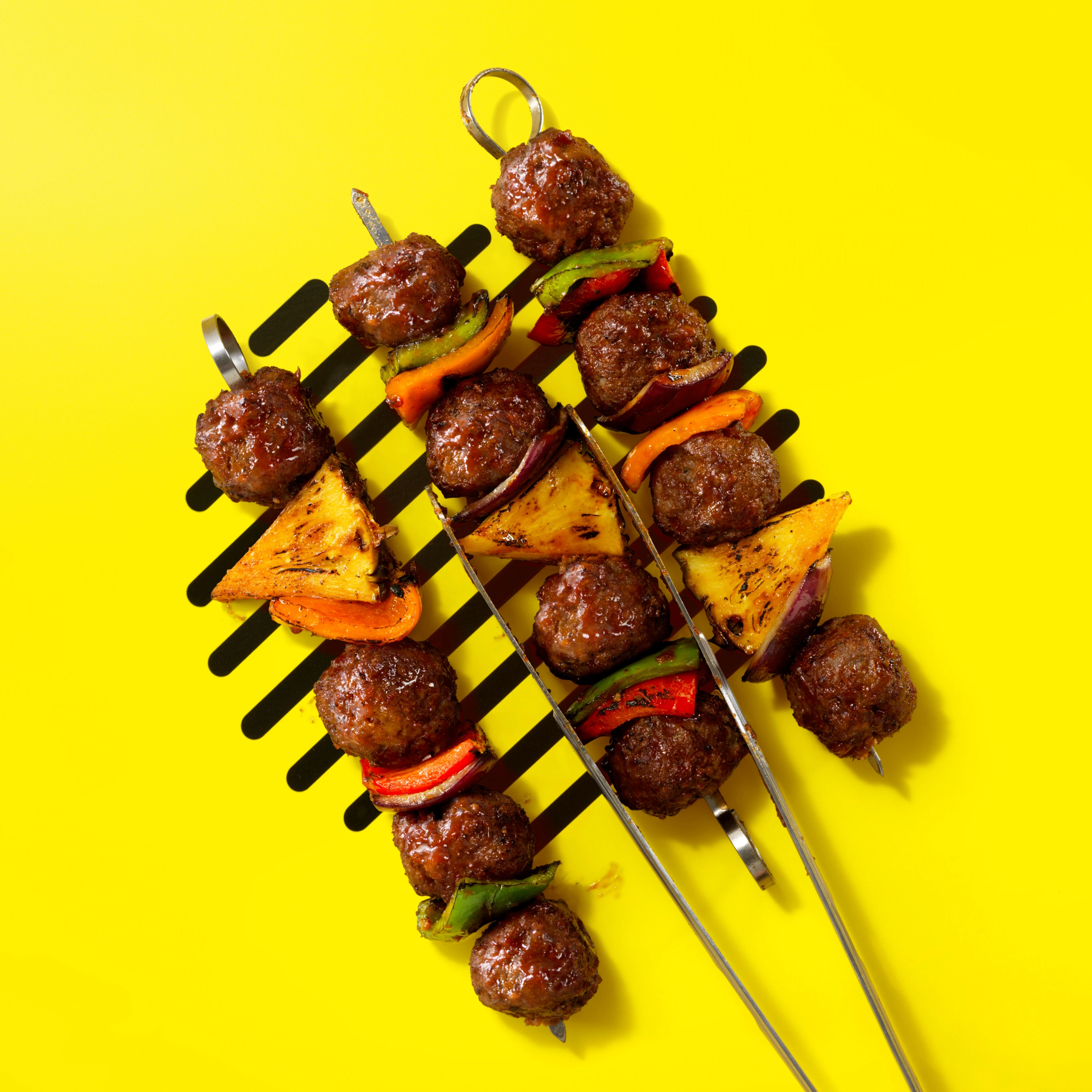 Impossible Burger Mini Hawaiian Kabobs skewer on yellow background with grill lines
