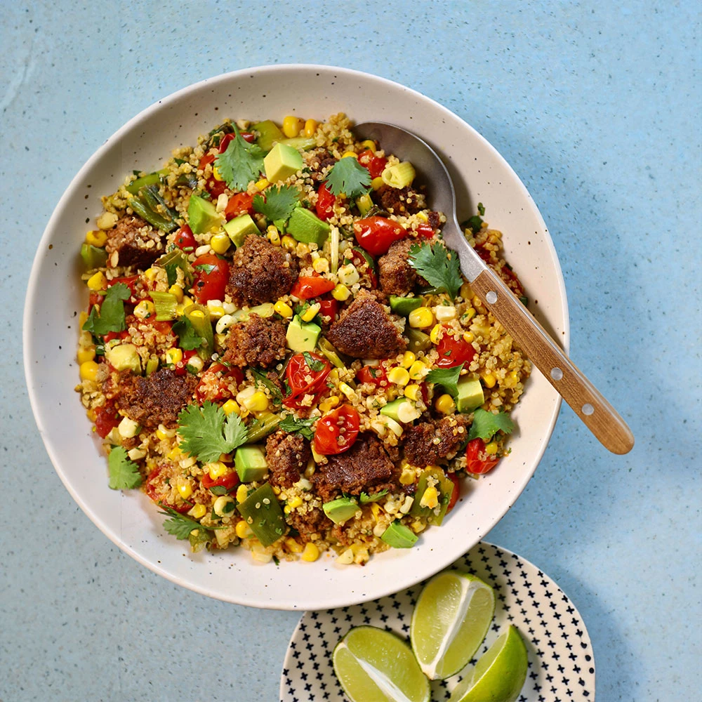 The Impossible Summer Veggie and Crispy Quinoa Bowl featuring Impossible Beef Made From Plants, roasted corn and tomatoes, crispy quinoa, fresh cilantro and lime juice, and diced avocado. 