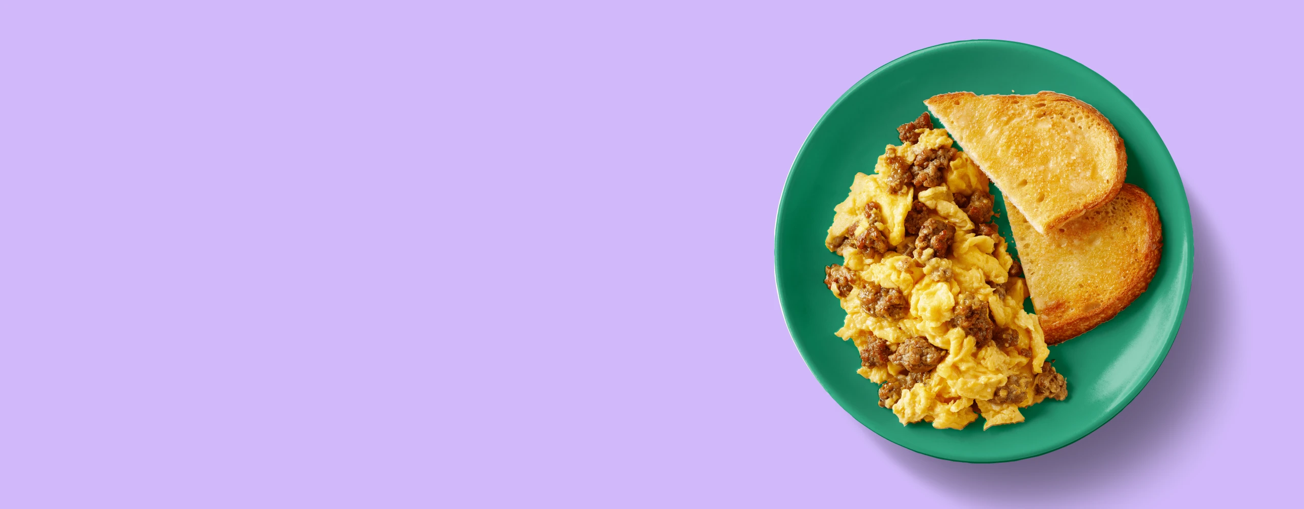 Impossible sausage scramble with toast on a plate purple background