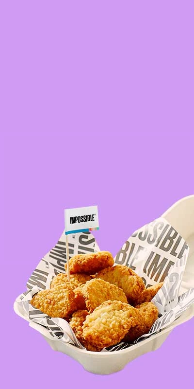 Impossible Chicken Nuggets with an Impossible toothpick flag in a takeout container on a purple background