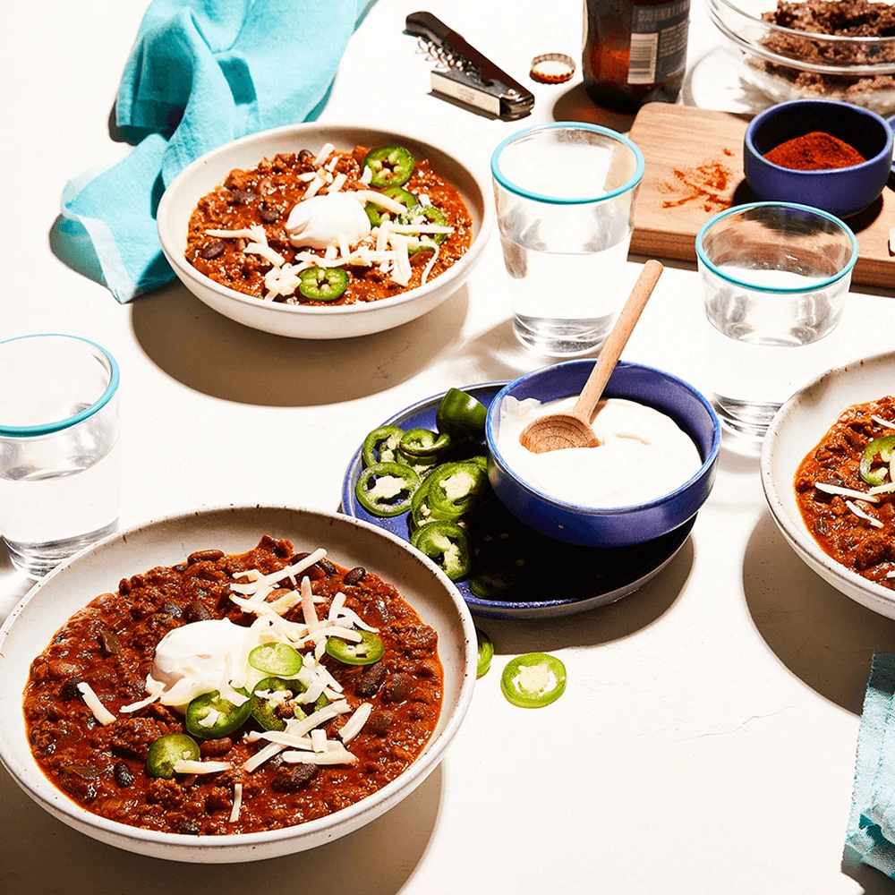 Easy Impossible Foods Chili with Lime Crema Recipe made with Impossible Burger plated on table 