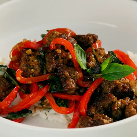 Impossible Spicy Thai Beef over white rice and garnished with fresh basil. 
