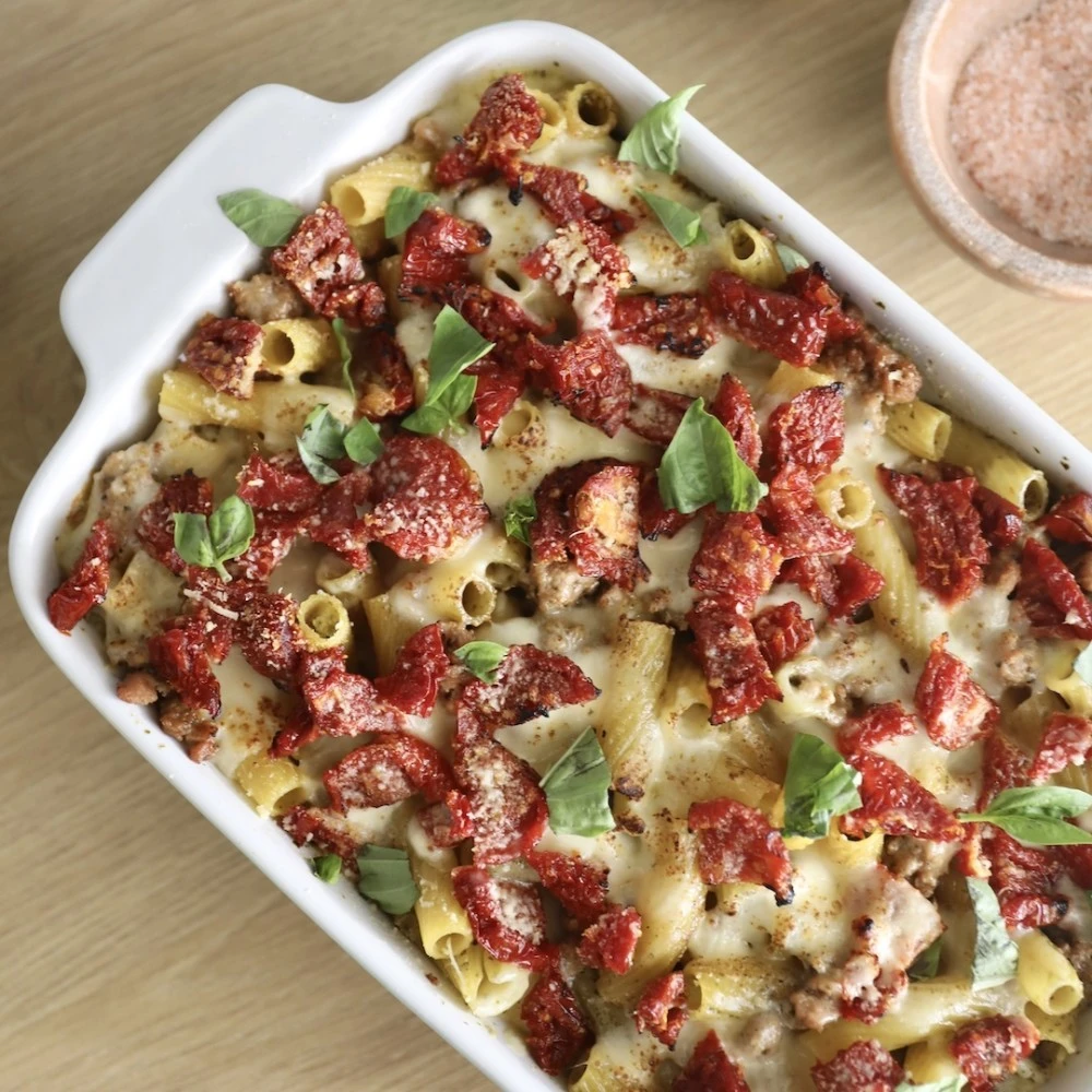 A cheesy, bubbling pesto pasta bake with Impossible Sausage, sun-dried tomatoes, and freshly torn basil. 