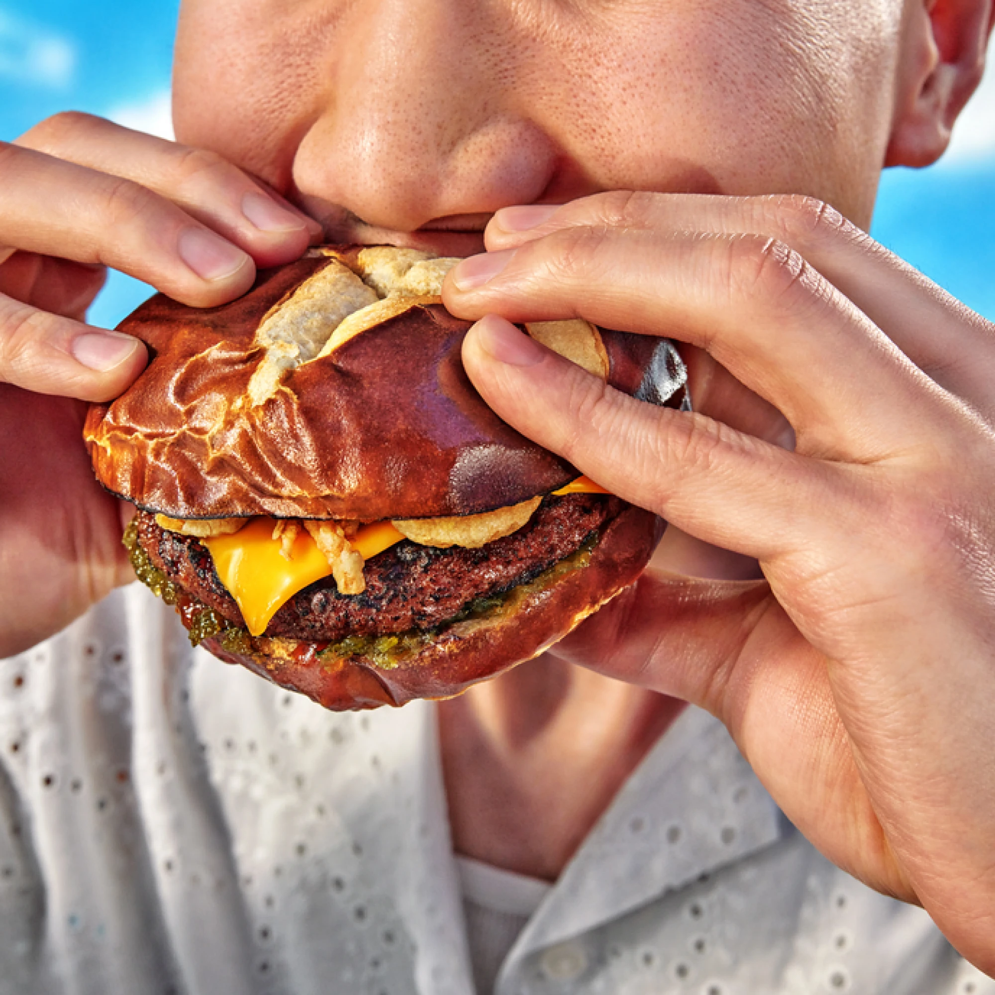 Person eating a burger with an Impossible Beef Patty