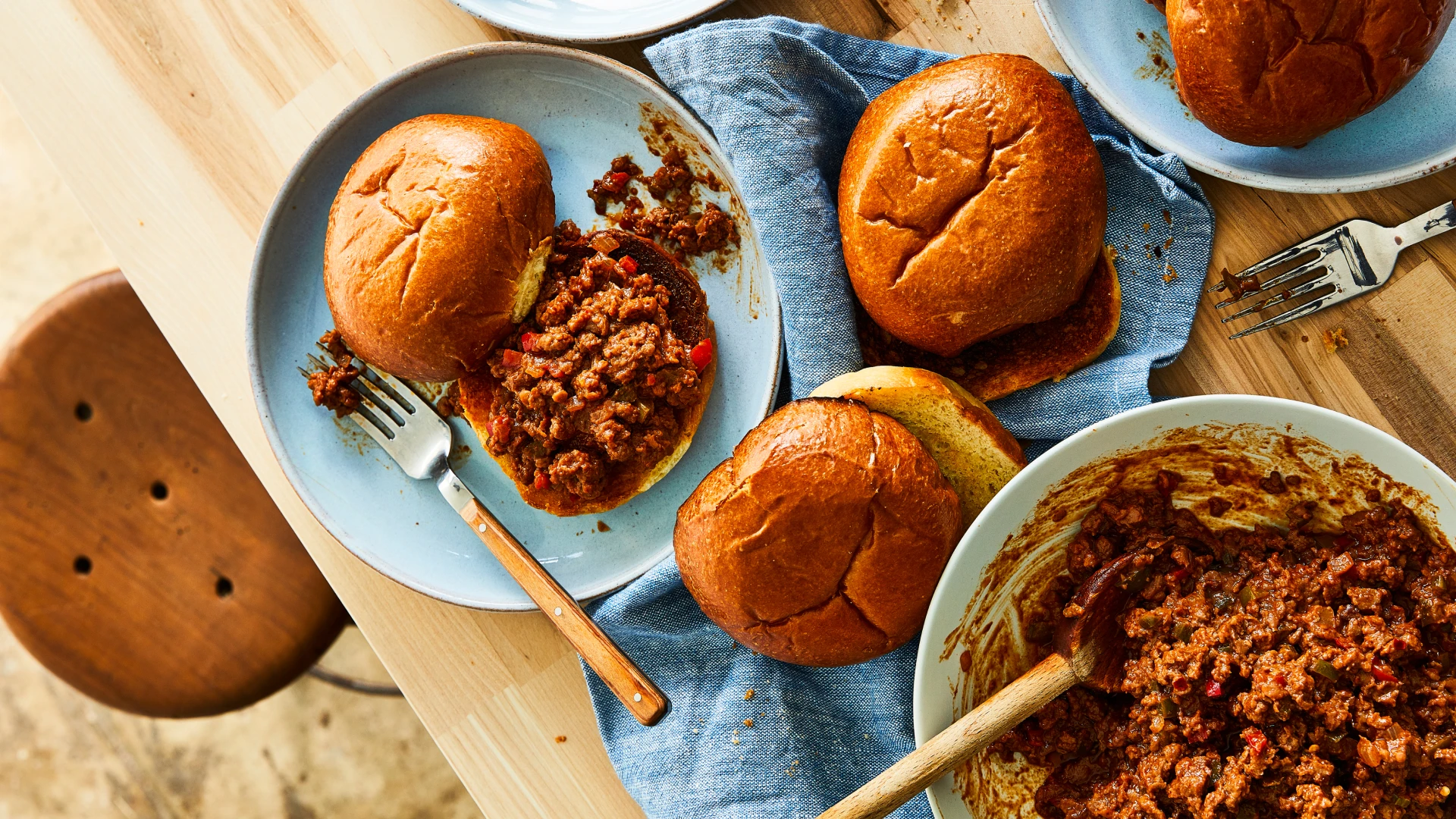  Impossible™ Sloppy Joes recipe by Tanya Holland with buns on plates and in a bowl on a table with forks