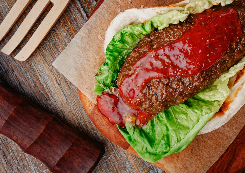 Impossible Satay Prata over lettuce served on wooden block
