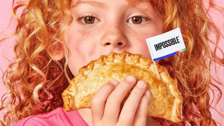 Little girl holding an Impossible Empanada with a flag