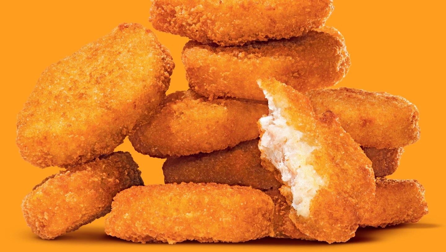 A stack of crispy Impossible Chicken Nuggets on a vibrant background.