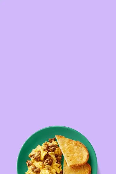Impossible sausage scramble with toast on a plate purple background