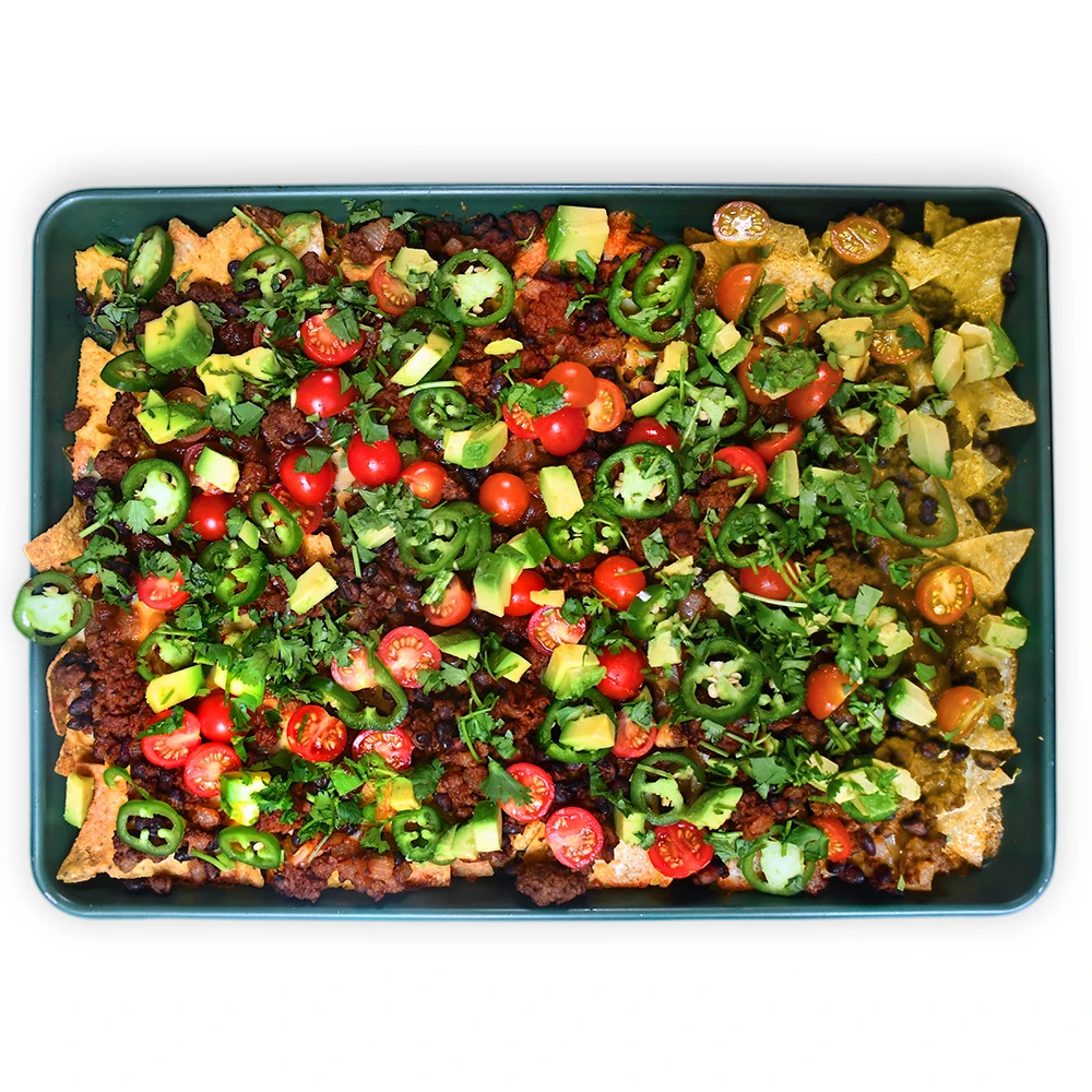 Impossible™ BBQ nachos, piled with Impossible™ Burger, Haven’s Kitchen’s Tangy BBQ sauce, bright veggies and cilantro 