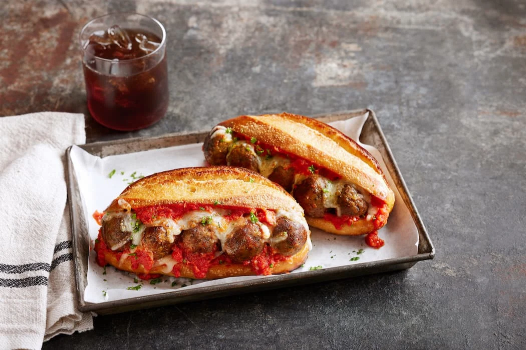 Impossible Meatball Sub served on a tray with coke