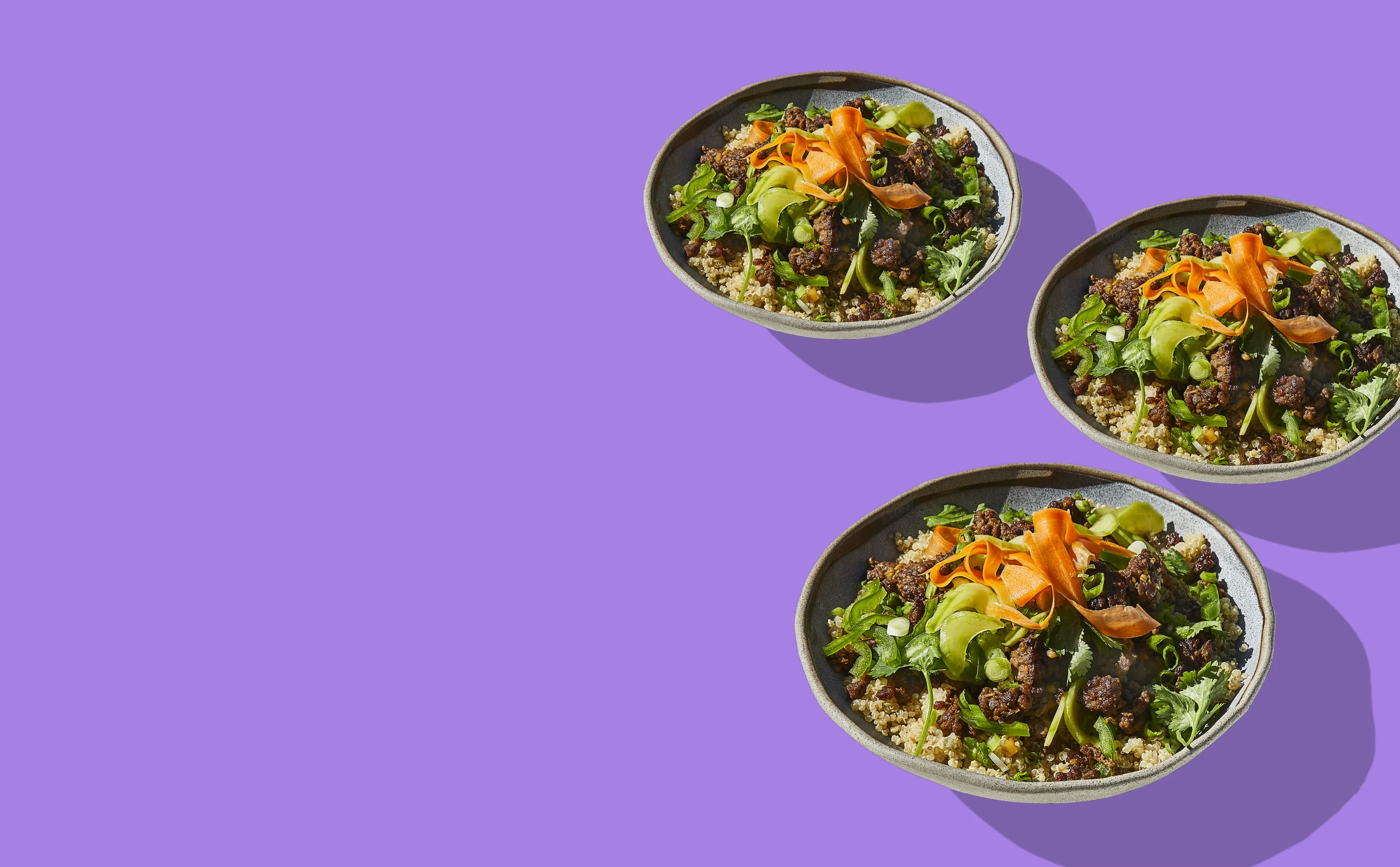 Impossible Quinoa Bowls made with Impossible Beef on a plate on purple background 