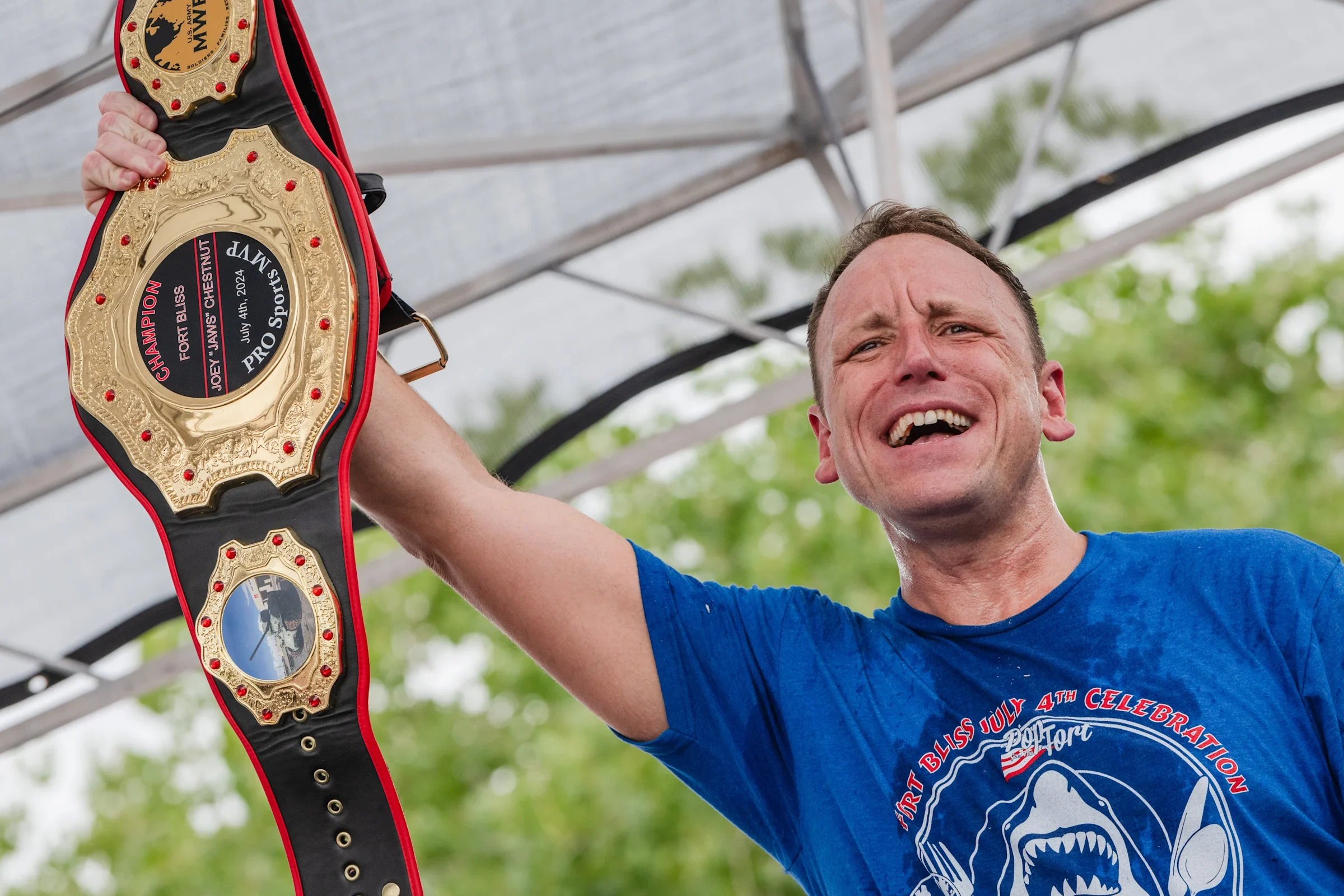 Joey Chestnut holding a belt title