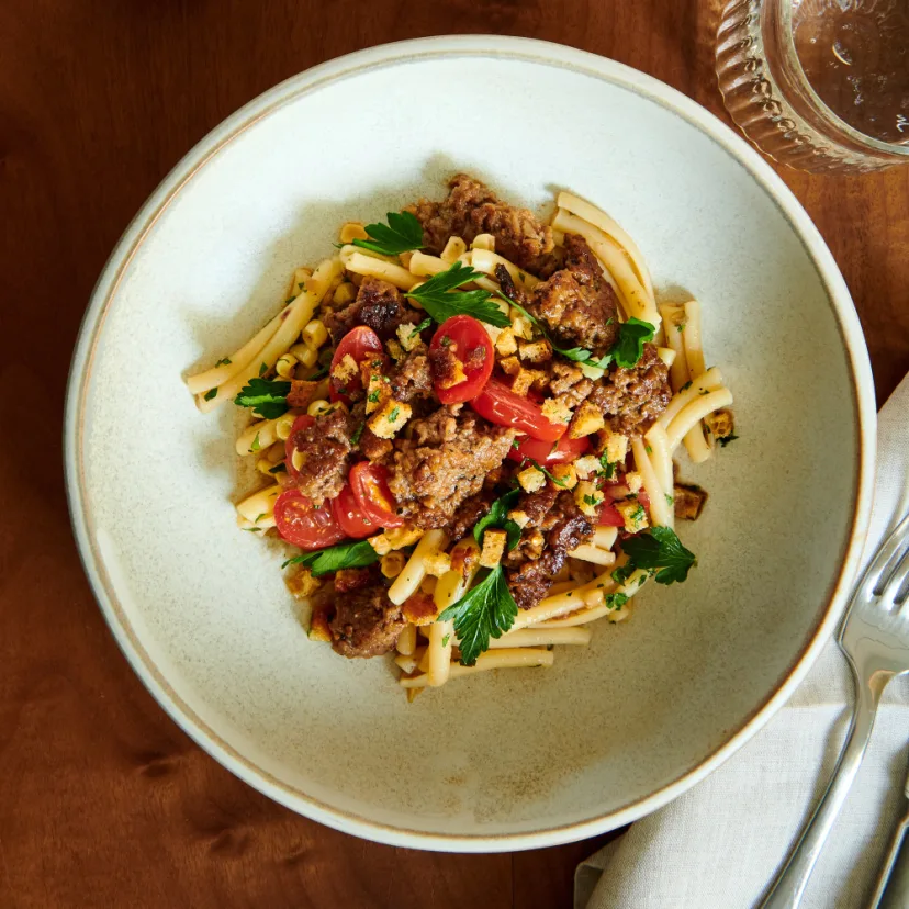 Impossible™ Spicy Sausage, Corn and Cherry Tomato Pasta with meat made from plants, toasted French bread crumbs and fresh parsley. 