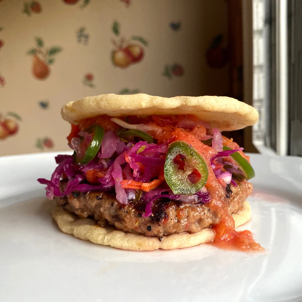 Cook this Impossible™ Pupusa Burger recipe, prepared with meat made from plants, a curtido slaw, salsa de tomate and served on homemade corn buns.