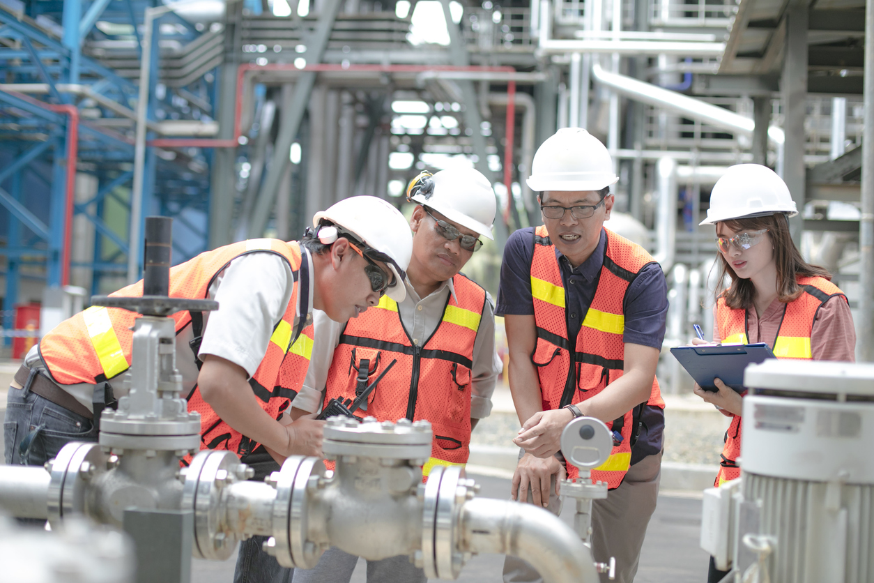 A group of employees on a job site reviewing gas meters