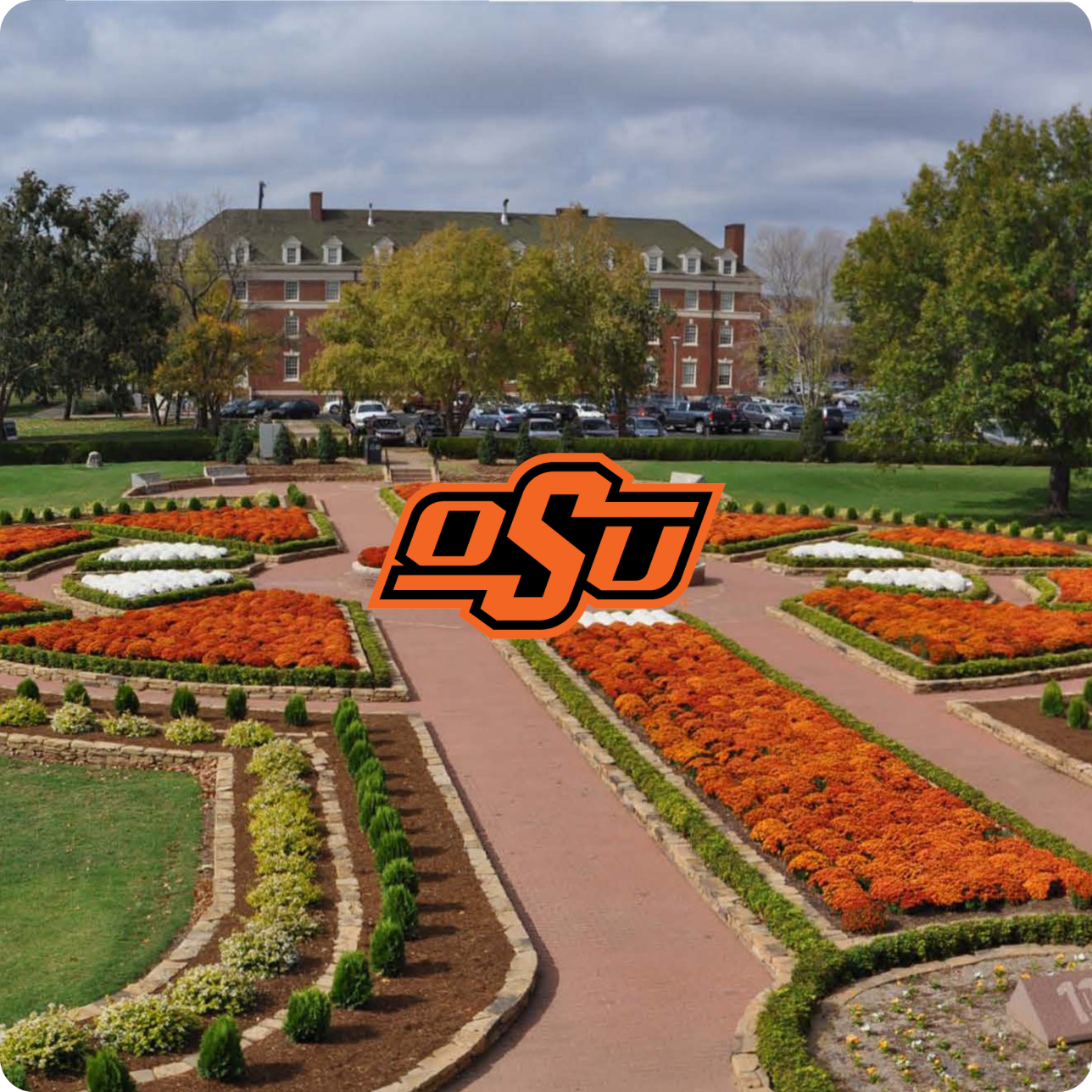A photo of the Oklahoma State University Campus courtyard with school color flowers. The OSU logo is in the middle of the photograph.