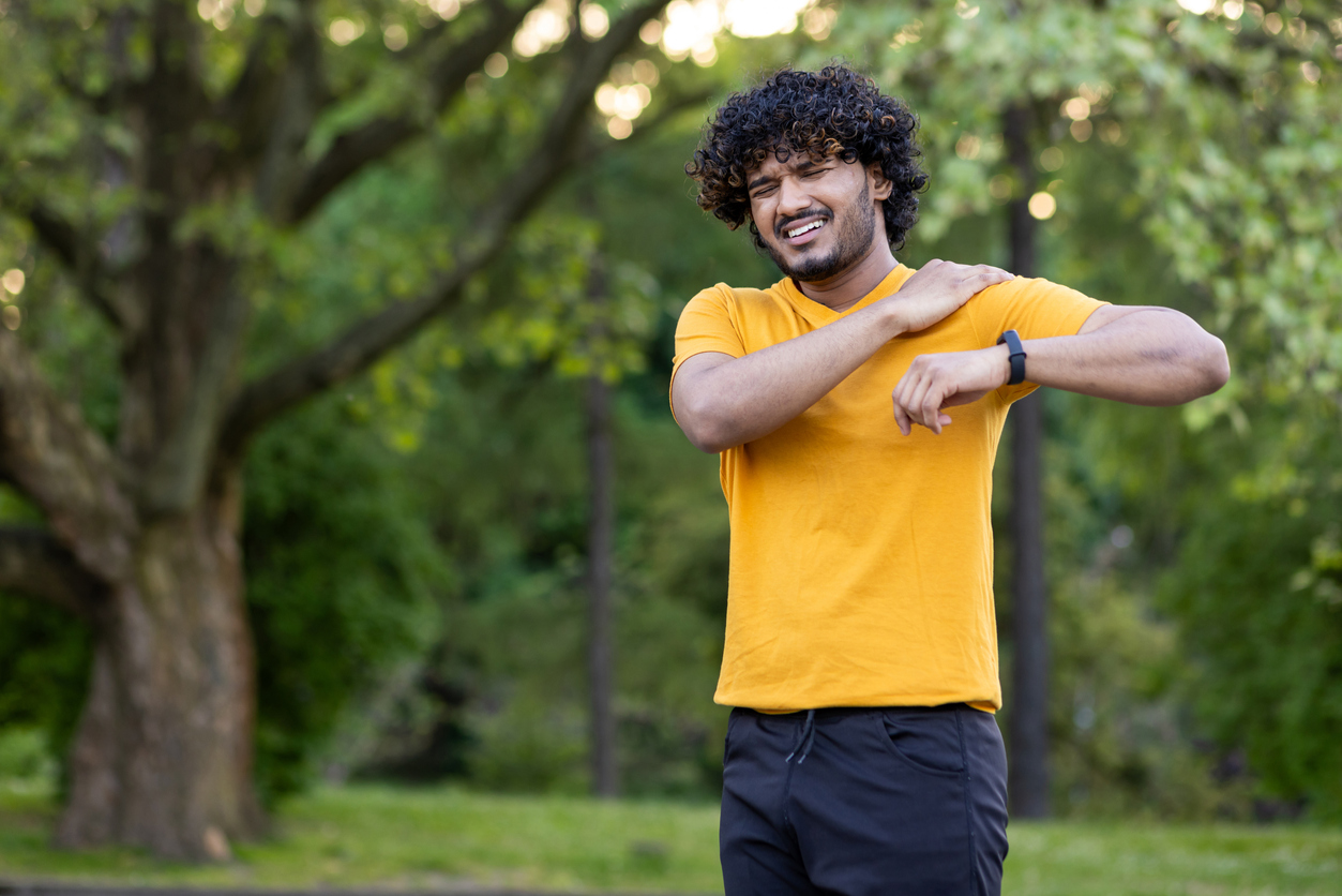man feeling shoulder pain when running