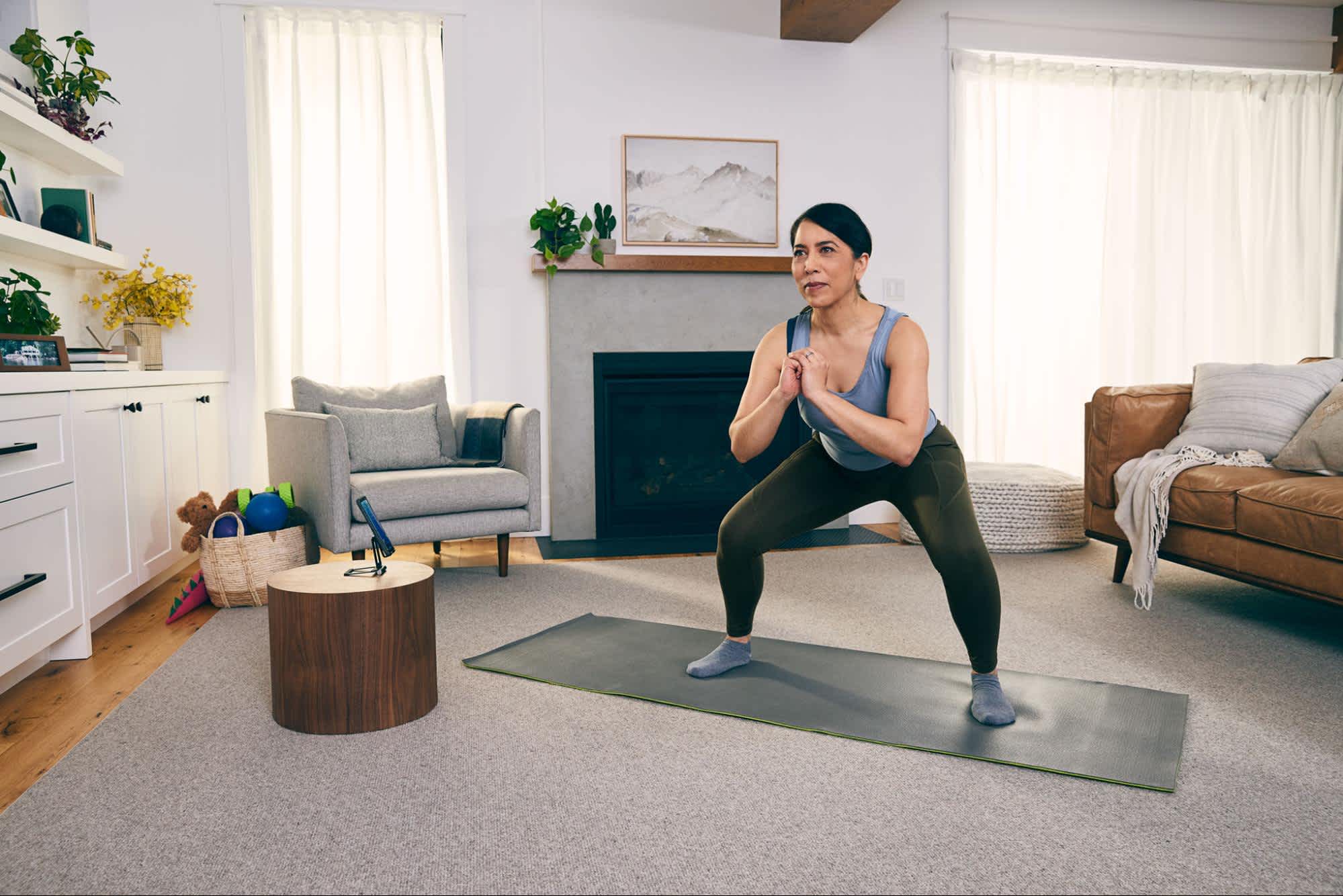 Woman doing squats in her living room. 