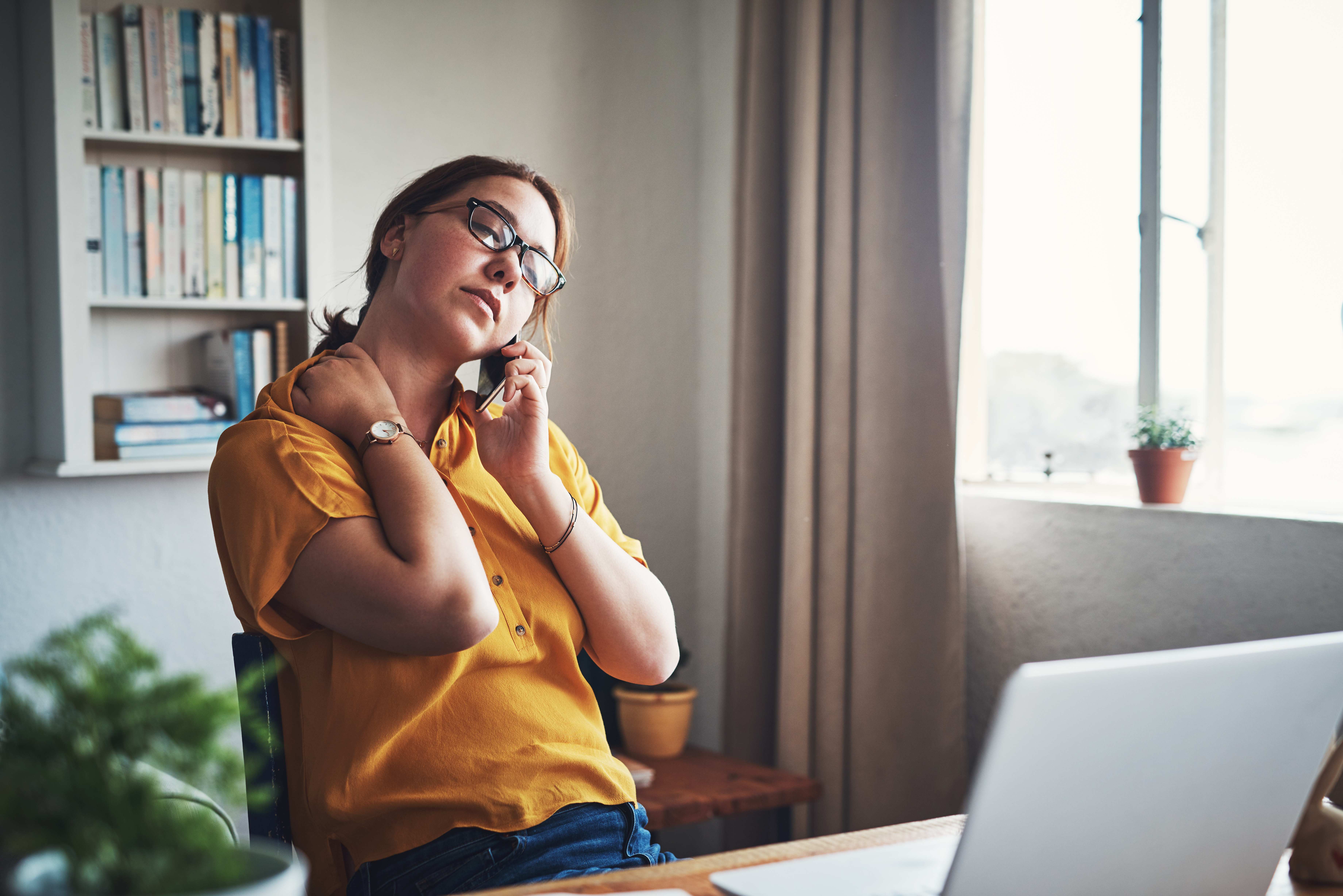 Woman-at-home-office-stretching-neck-in-pain
