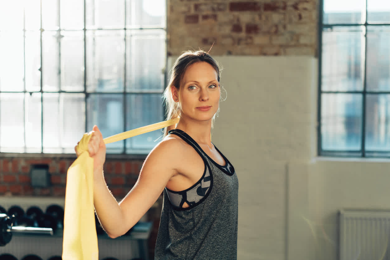 Woman-stretching-using-band-at-gym