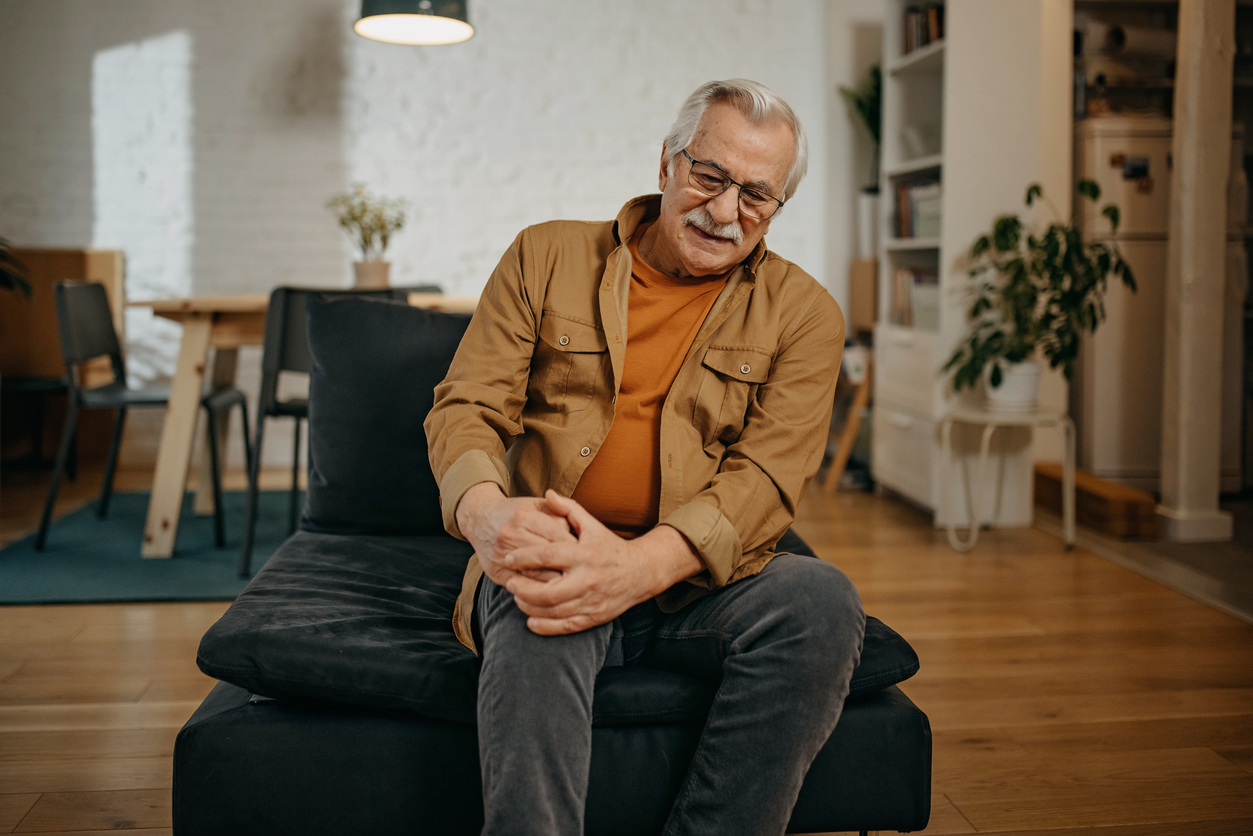 man feeling knee pain after hip replacement