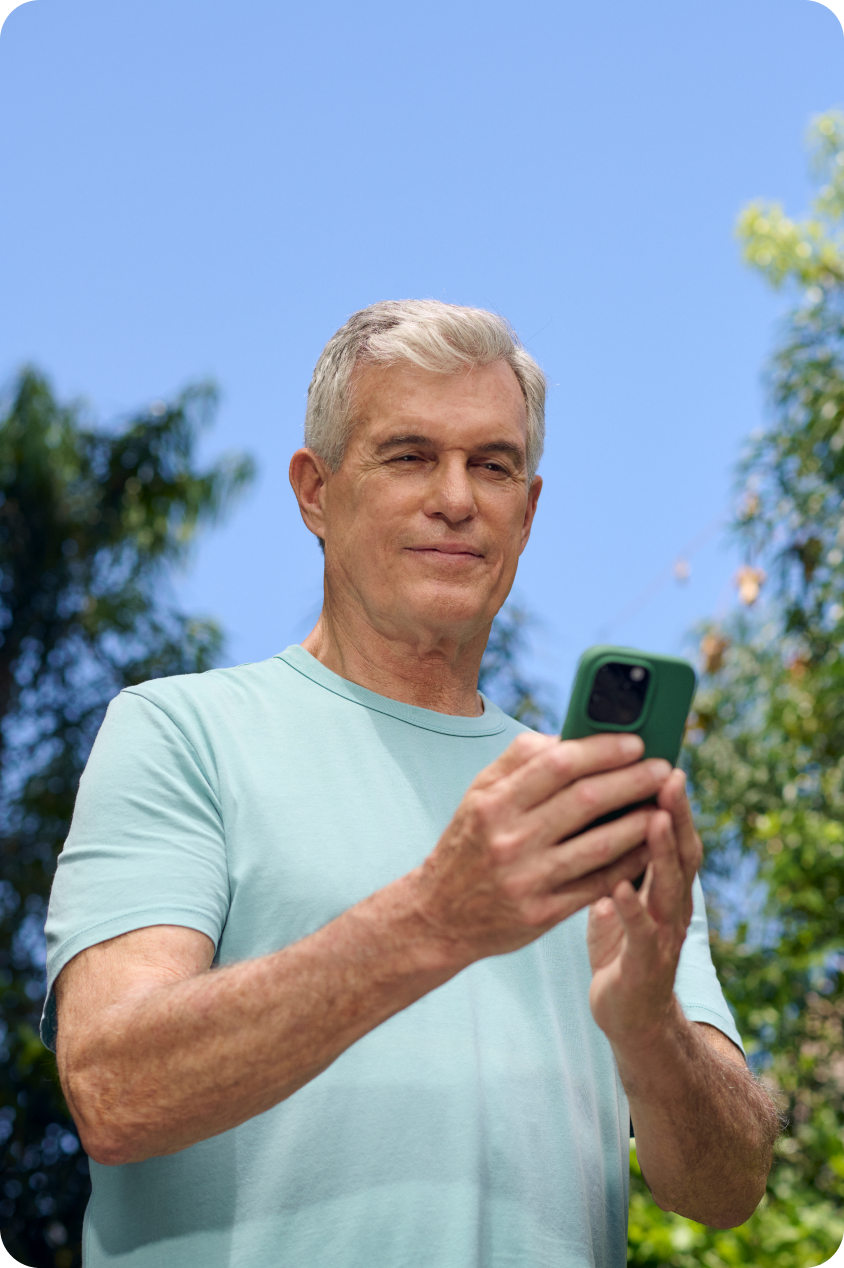An older man looks at his phone, confirming a video visit in the app