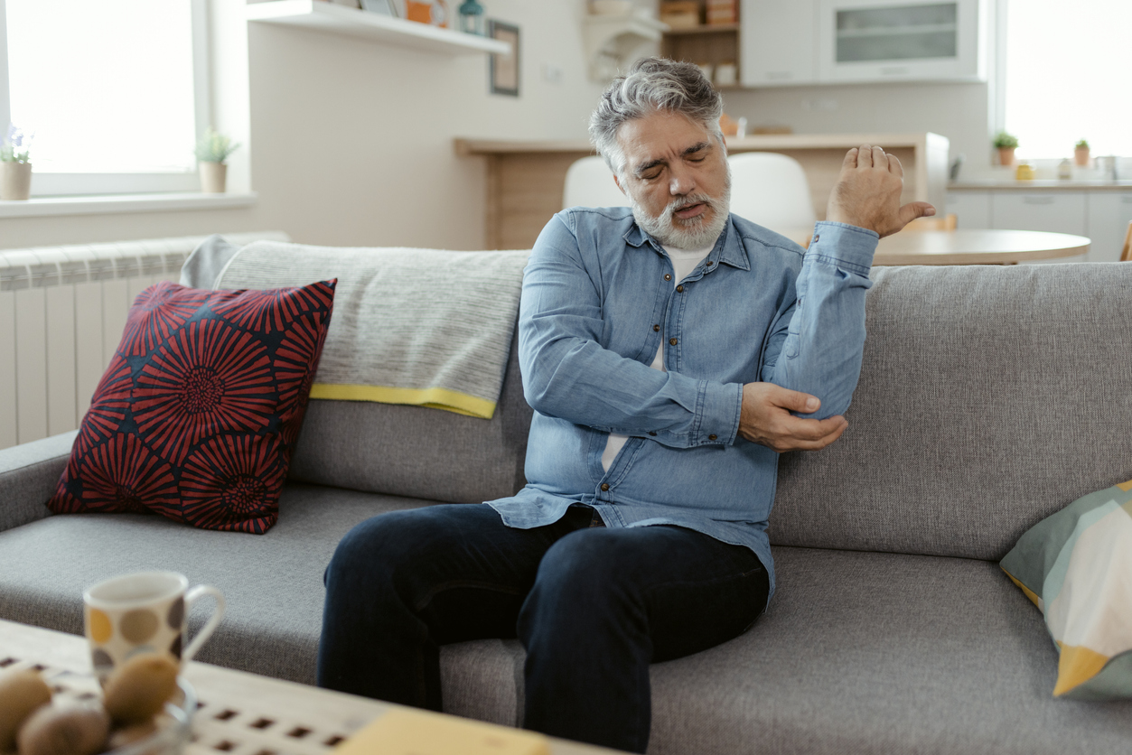 an-old-man-holding-his-elbow-in-pain