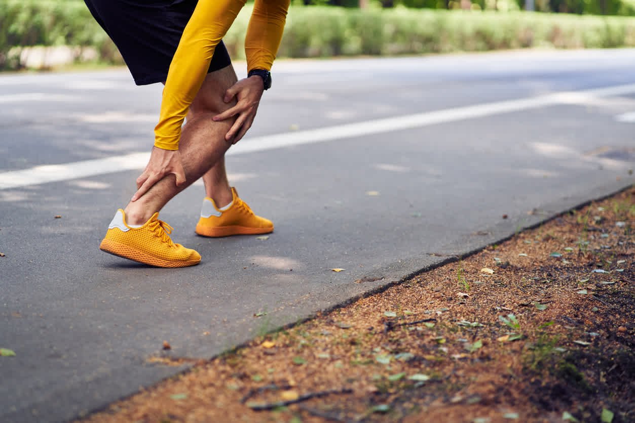 man-touching-her-foot-oin-the-road