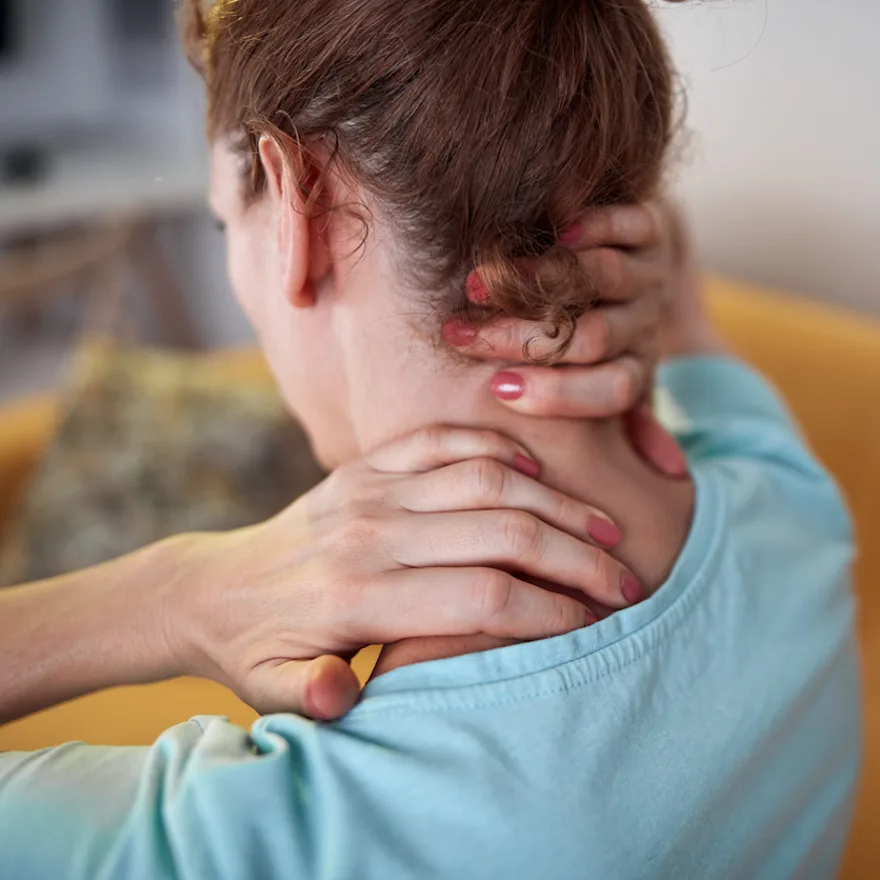 Photo of a woman robbing her neck with both hands