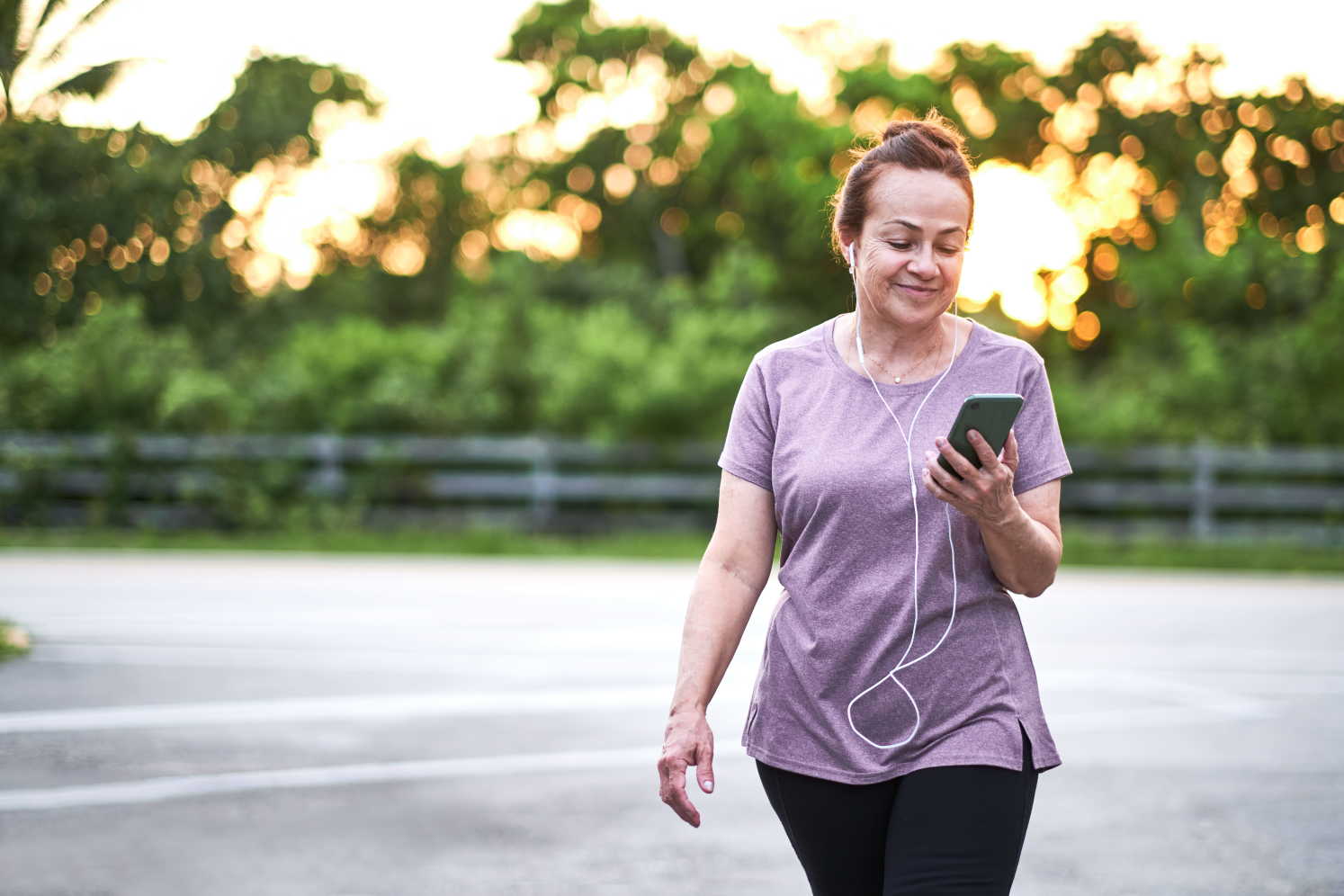 Elderly-woman-walking-outdoors-smiling-and-listening-to-music