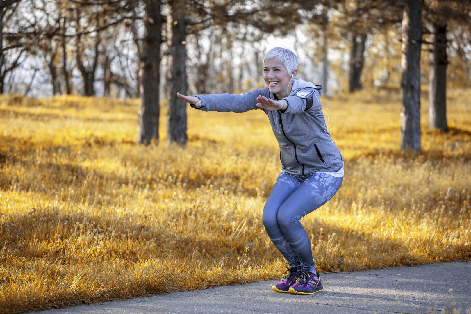 Senior woman doing squats outdoors
