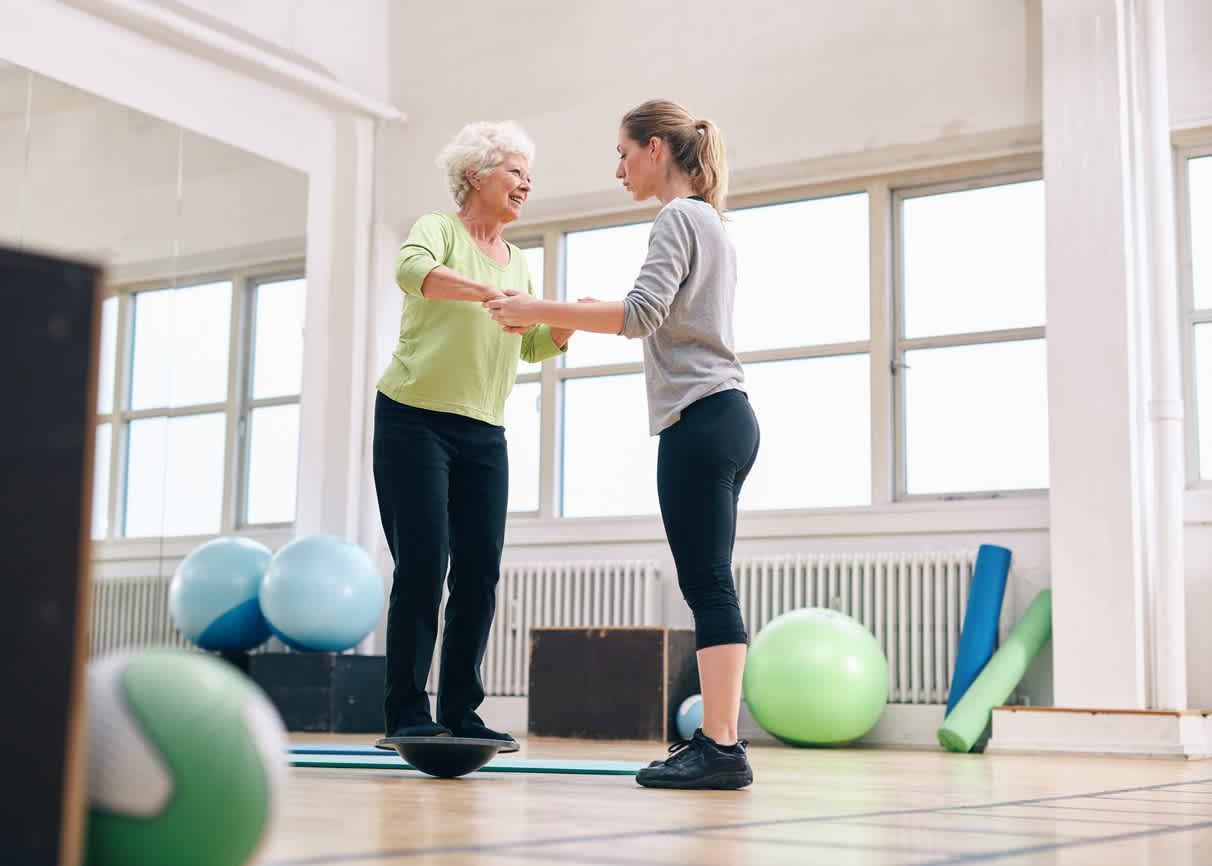 woman-helping-elder-woman-exercise