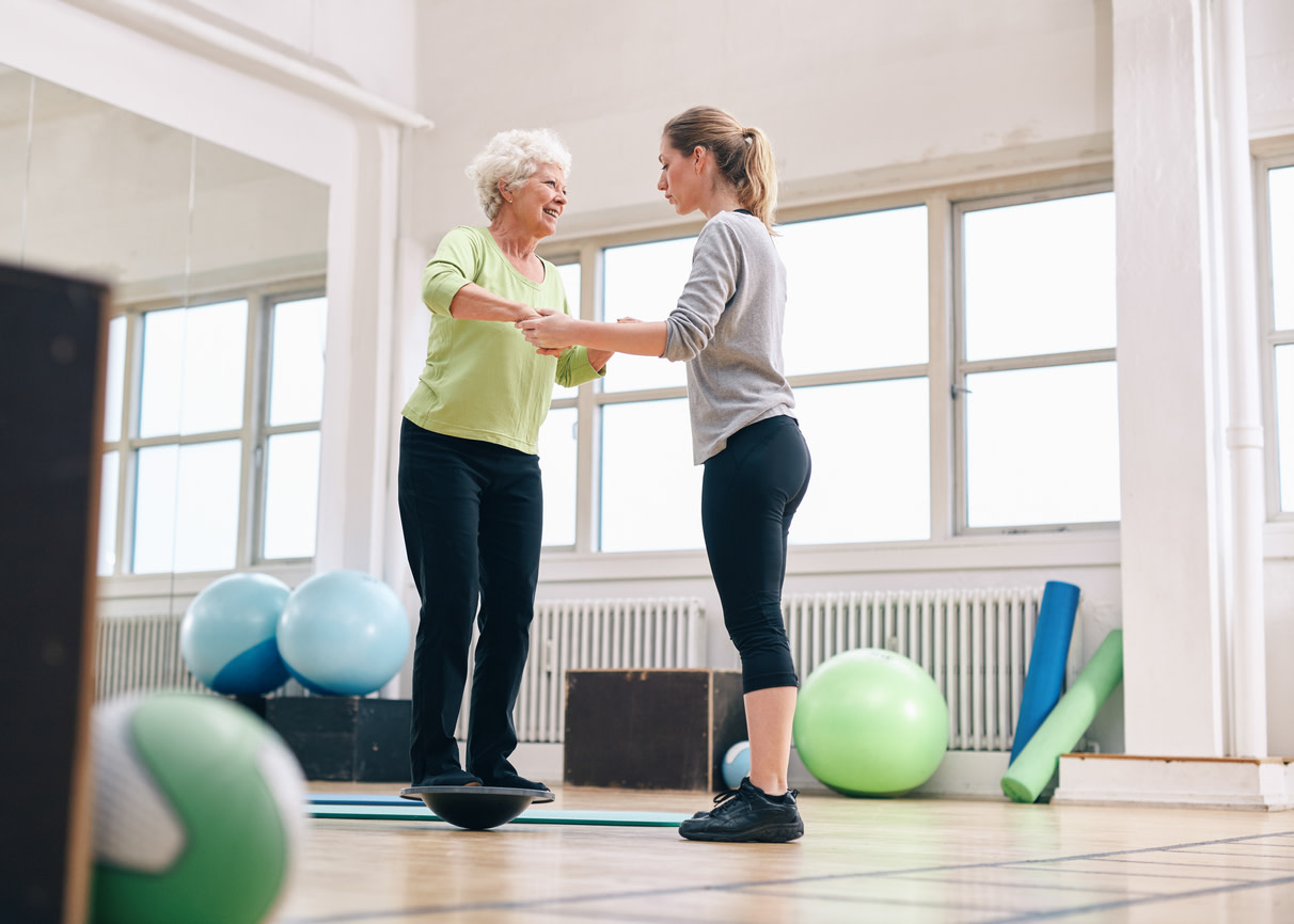 woman-helping-elder-woman-exercise