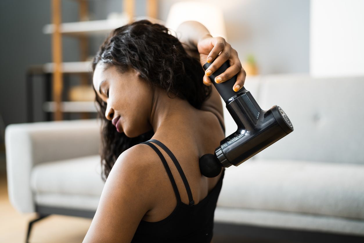 woman-using-massage-gun-in-her-back