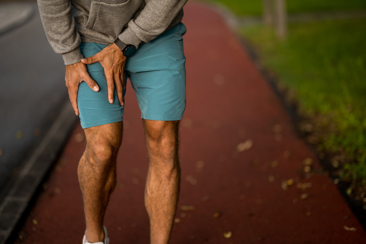man feeling hip pain radiating down leg to foot