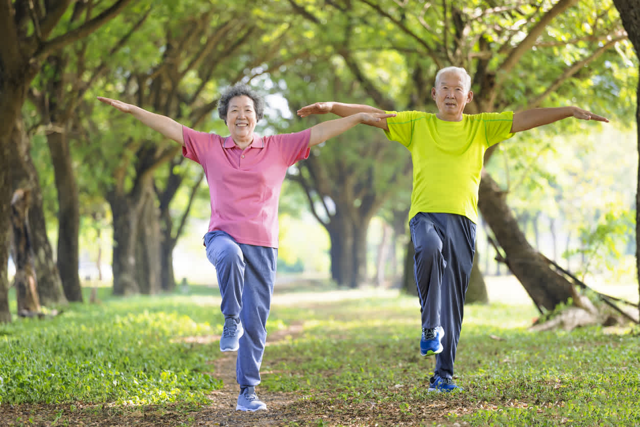 asian-man-and-woman-doing-balance-exercises-at-park