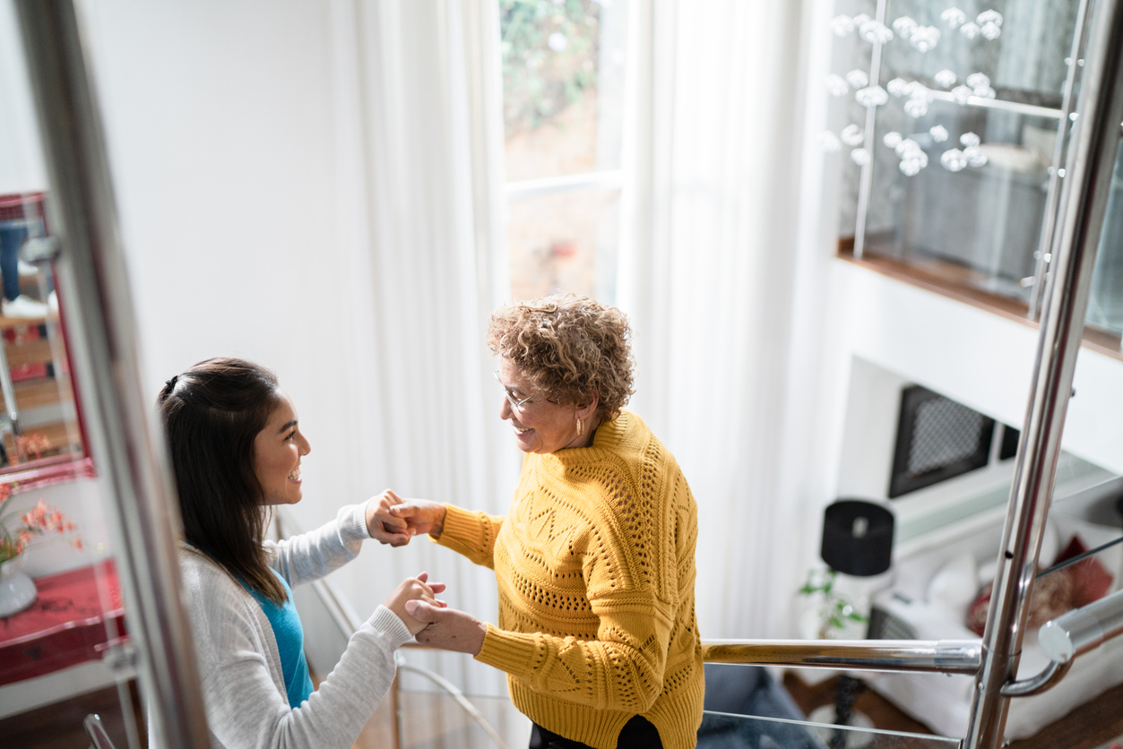 Two women practicing physical therapy exercises to prevent muscle atrophy. 