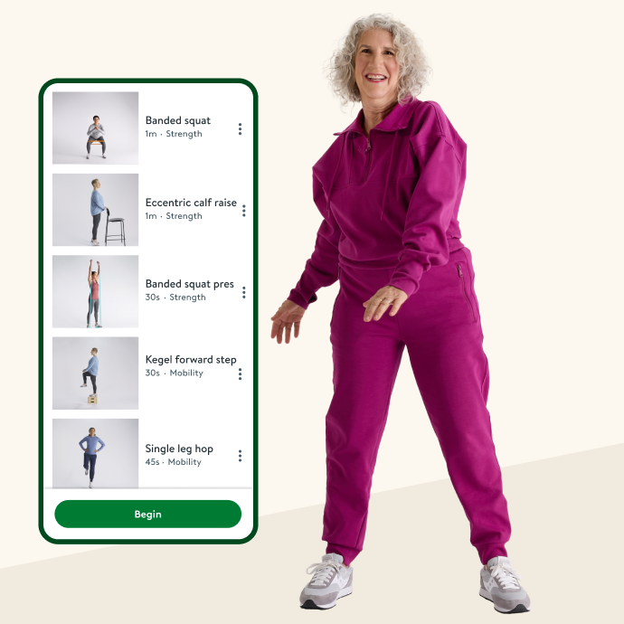 Woman standing next to a mobile phone displaying the Hinge Health app playlist screen