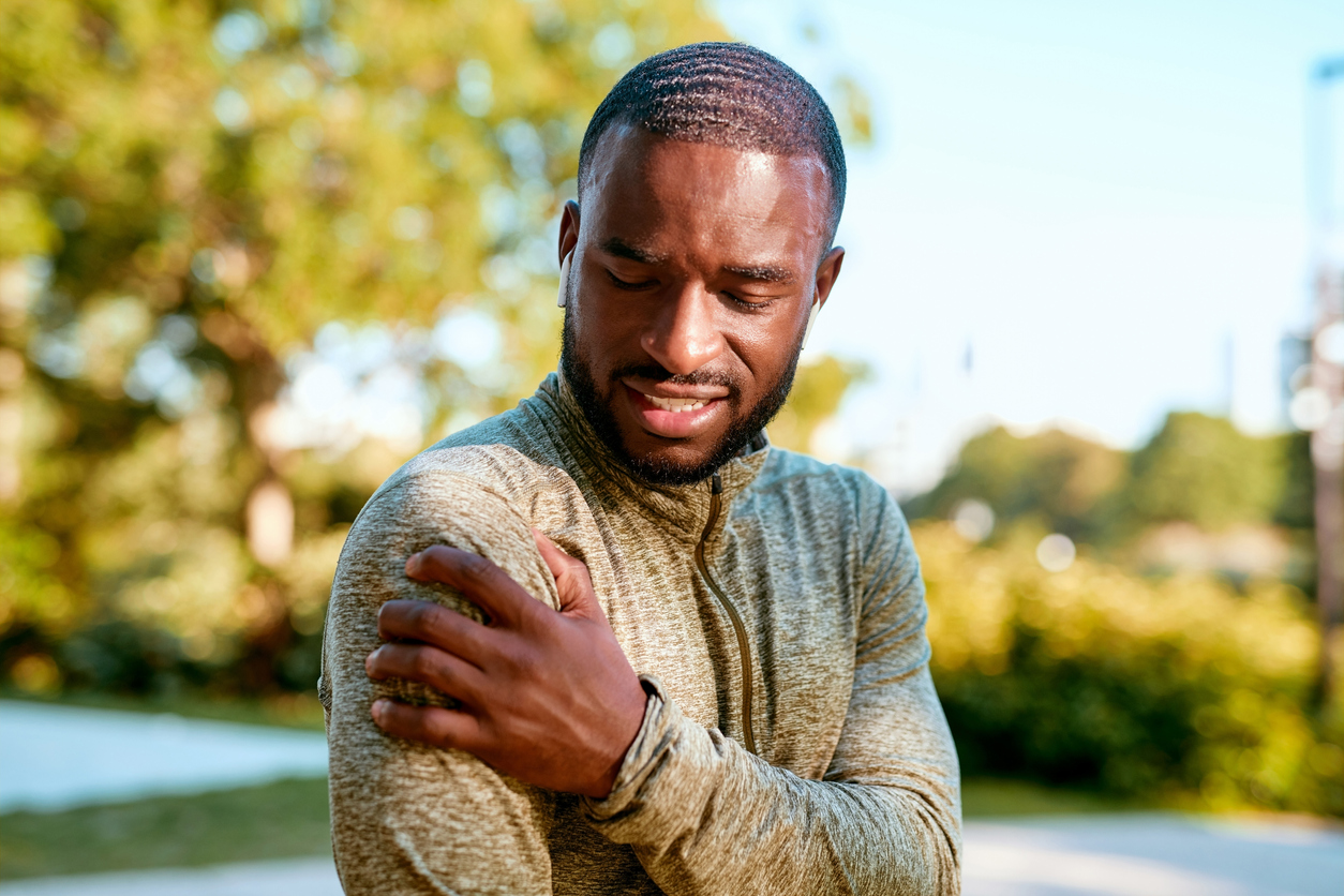 man-touching-his-bicep-in-pain